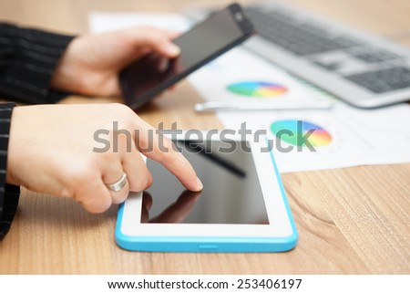 Busy businesswoman is working on tablet computer and using smart mobile phone