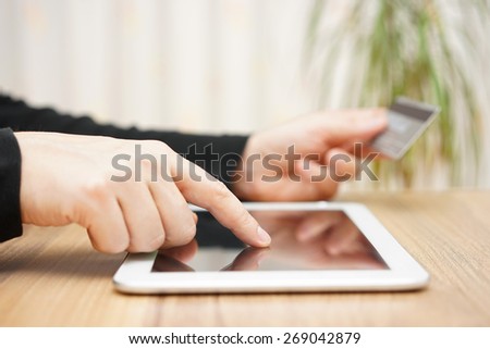 Man is using credit card for on line payment on tablet computer