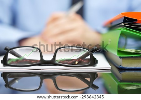 financial consultant in background with eyeglasses  in front with growing arrows, business and success concept