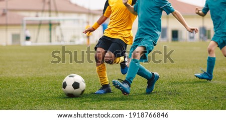 Running Footballers. Children Kicking Soccer School Tournament Match. Multiethnic Children Playing Sports. Young Athletes Compete in Football Game