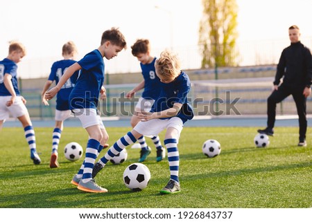 Soccer Education for Young Boys. Physical Education Class for School Children. Young Coach With Kids in Team on Training Unit. Youth Team Coach Training School Boys in Football Soccer