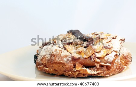Croissant with toasted almonds and chocolate, dusted with confectioner\'s sugar