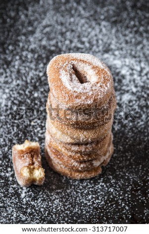 Typical spanish donuts, fried rosquillas with sugar for breakfast, over black background