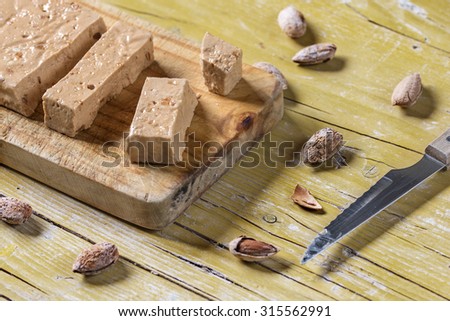 Turron, typical Spanish Christmas dessert for Christmas served in a wooden table over yellow background