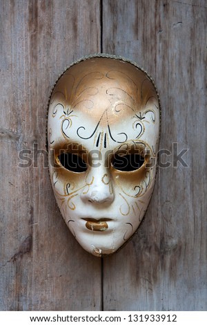 A fancy mask on the wood wall.