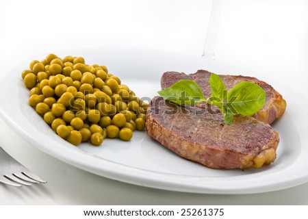 Dish of meat and peas with basil, studio shot.