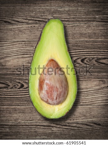 Avocado cut on wooden table, close up.