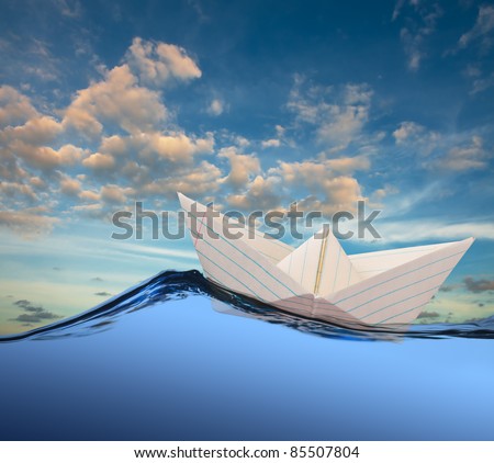 White paper boat floating in the sea.