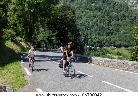 LARUNS,FRANCE- JUL 15:A boy and his father climbing on the road to mountain pass Aubisque just before the passing of the peloton during the 13th stage of Le Tour de France on July 15 2011.