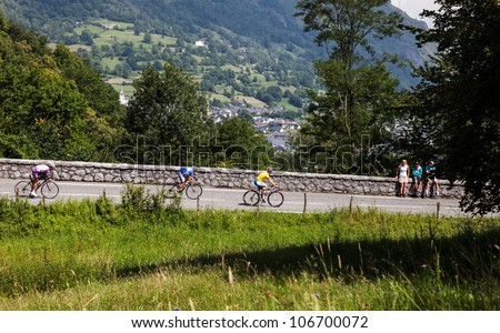 LARUNS,FRANCE- JUL 15:Three amateur cyclists going down fastly on the road to mountain pass Aubisque just before passing the peloton during the 13 stage of Le Tour de France on July 15 2011.