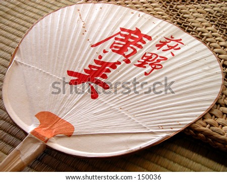A characteristic Japanese paper fan on a tatami floor.