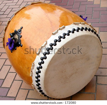a traditional japanese wooden drum in on the pavement during a street show break.