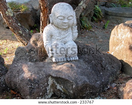 A little Buddhist rock statue in a Japanese rock garden