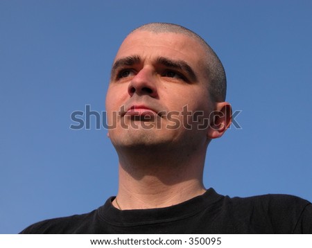 Bald-headed man with sad expression-over natural blue sky