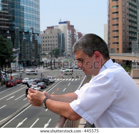 Man using a mobile phone to read an email in a modern city