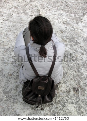 Hiking woman with backpack resting on a calcareous rock-interesting perspective from above.