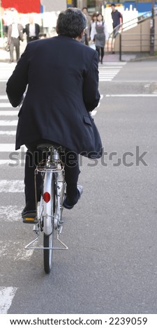 A rich Japanese businessman wearing suit and.....slippers riding a 50$ bicycle during lunch time period of the day.........a story about Japan\'s contrasts.....