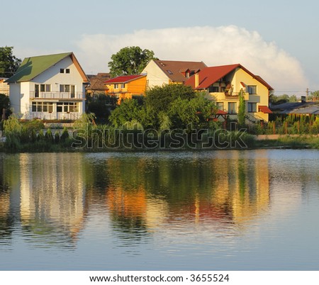 Beautiful reflections of some holiday houses in a lake in the dusk.