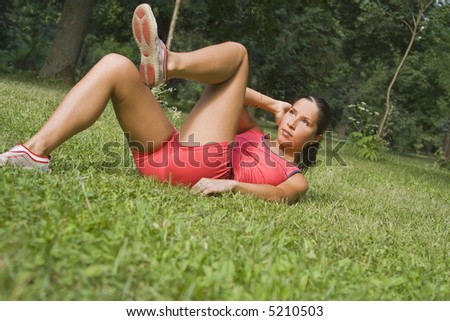 Young girl doing fitness outdoor in a park.