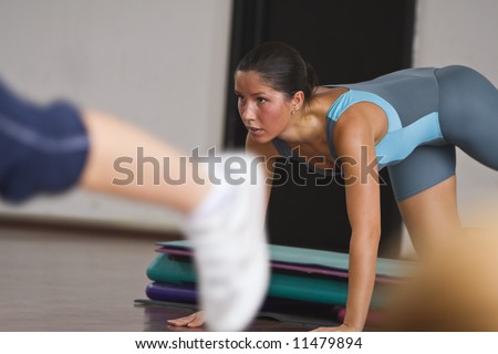 Close-up image of a woman doing aerobics in a fitness gym. Composition intended to accentuate the dynamism of the image.