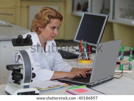 Female researcher working on a laptop at her workplace in a laboratory.All inscriptions are mine.