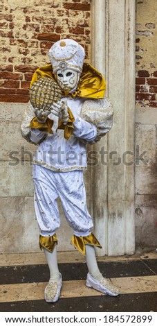VENICE-MAR 02:Unidentified person disguised in a white costume with a globe poses near the wall of Doge\'s Palace on March 02,2014 in Venice, Italy, during the Carnival days.