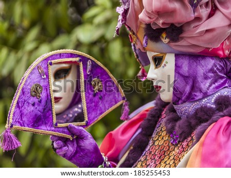 ANNECY,FRANCE,MAR 15:Portrait of a person in a mask looking in a mirror in Annecy,France,on March 15 2014.Every year here is held a Venetian Carnival to celebrate the beauty of real Venice