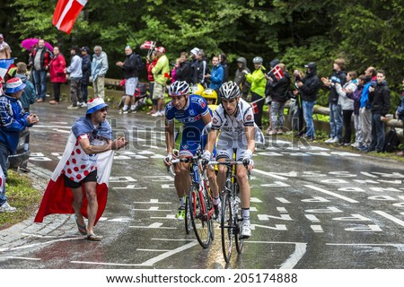 LE MARKSTEIN, FRANCE - JUL 13:A fan cheers a group of three cyclists on the road to mountain pass Le Markstein during the stage 9 of Le Tour de France on July 13, 2014.