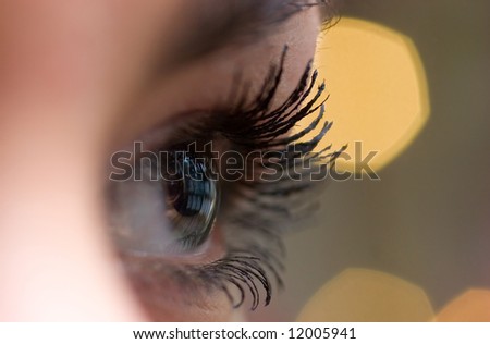 beautiful woman`s open  eye over blurred background