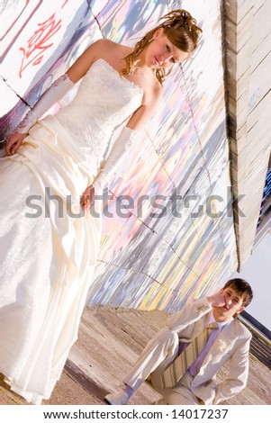 Happy bride and groom against graffiti wall background