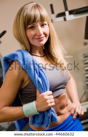 Beautiful athletic woman with towel in gym