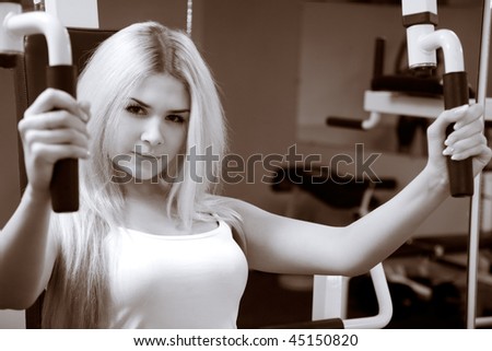 Young blonde exercising in gym. Black and white