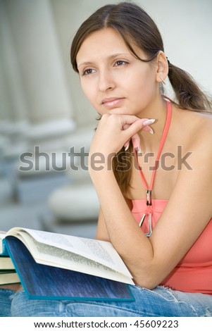 Young girl dreaming with book in hands