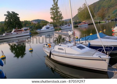 Motorboats and small yachts in a bay at dawn with reflection