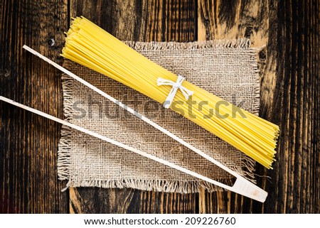 Pasta spaghetti over burlap on vintage wooden table  view from top