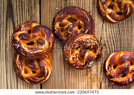 Pretzels, traditional German baked bread on rustic wooden table view from top. Rustic background