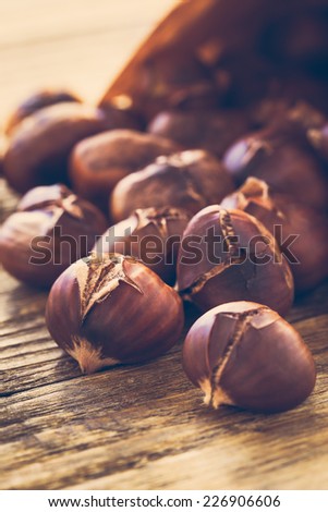 Delicious roasted chestnuts ready to eat on rustic wooden board
