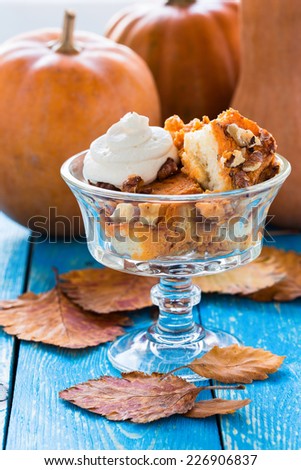 Pumpkin bread pudding topped with whipped cream, bread based pumpkin holiday dessert