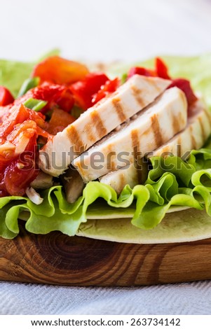 Homemade lettuce wrapped chicken fajitas served  on a flour tortilla with tomato salsa