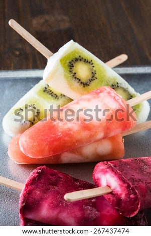 Homemade fruit juice popsicles with a stick. Vanilla ice cream with kiwi, berries and grapefruit juice