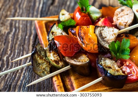 Fresh summer vegetable kebabs  with eggplant and cherry tomatoes, charred veggie skewers on cutting board, veggies eating concept