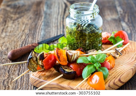 Fresh summer vegetable kebabs  with eggplant and cherry tomatoes, charred veggie skewers with  basil pesto sauce on cutting board, veggies eating concept