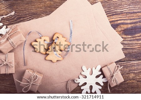 Craft paper blank card for holiday message, handmade gift boxes  and christmas cookies on wooden background, craft set handmade decorations viewed from above