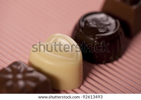 Chocolate heart close to chocolates. Selective focus