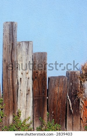 fence posts and blue wall