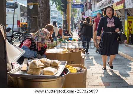 Seoul, South Korea - October 25, 2014: A street seller sells her wares on a Seoul sidewalk in Korea