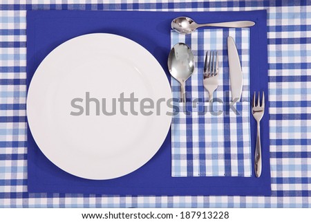 laid table/ fork and spoon laid on blue cloth in the kitchen