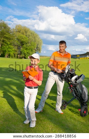 Father with son are counting points of game at golf course