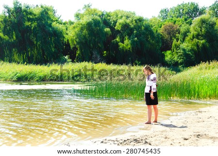 beautiful girl in the Ukrainian national clothes embroidery on the riverside