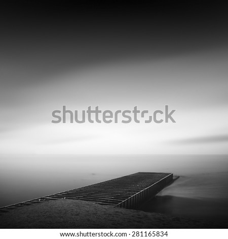 beautiful minimalist black and white seascape with sea wave cutter and milk water. shot taken in daytime with long exposure